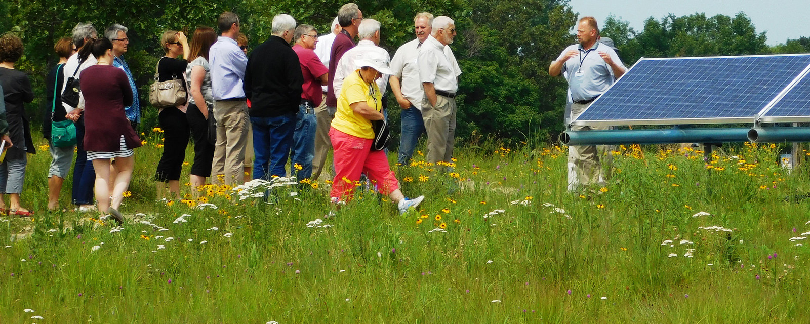 A group of people tours a community solar garden in Minnesota