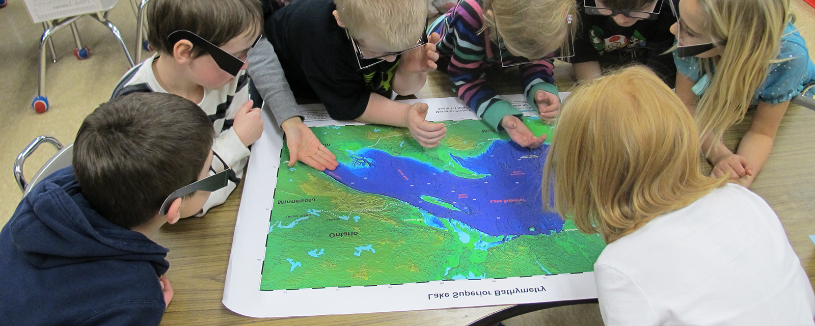 Children looking at a map of Lake Superior Children looking at a map of Lake Superior