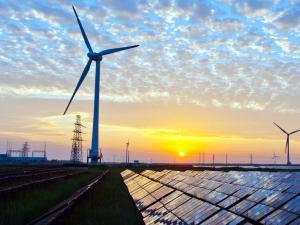 solar panels and windmills with sunset