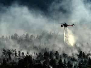 A helicopter drops water on the Waldo Canyon fire in June, 2012