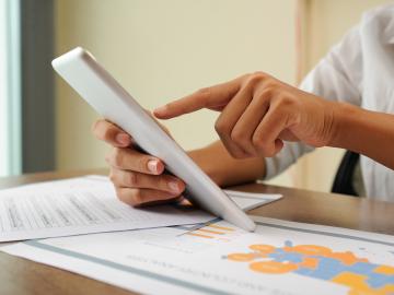 Closeup of person holding and using tablet