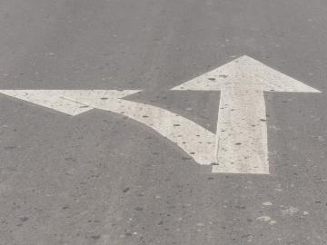 Cross arrow lines on asphalt