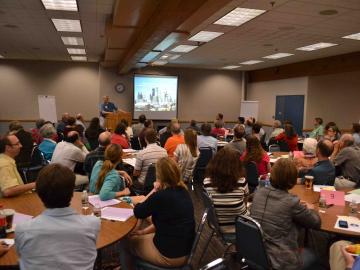 Room of people looking at projector screen