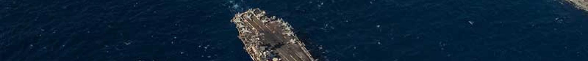 A picture of battleships at sea travelling in the same direction
