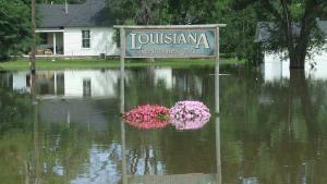"Louisiana Welcomes You" sign nearly submerged in floodwater