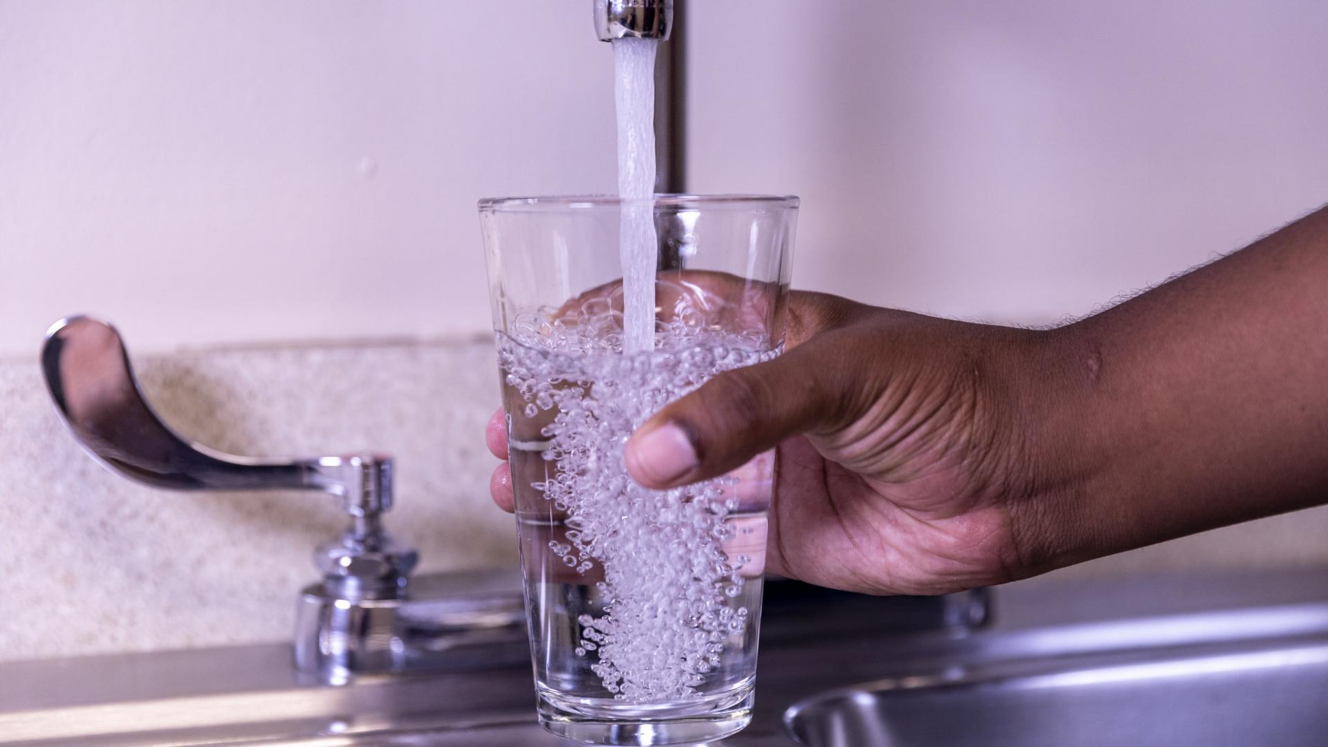 Filling a glass of water from the faucet.