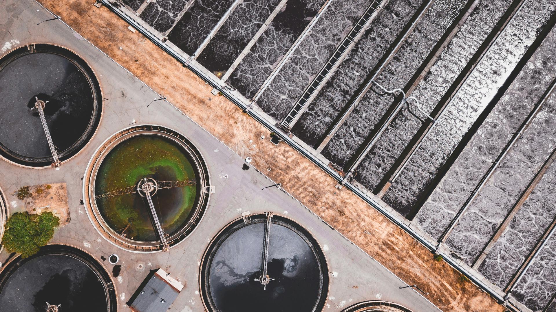 Aerial view of multiple filtration ponds outside of a wastewater treatment plant.