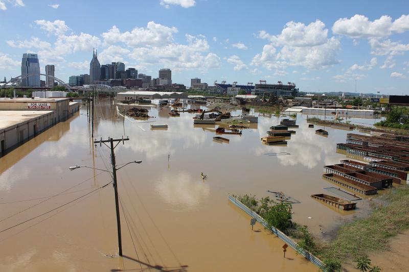 Flooding of industrial area with high-rise buildings in background