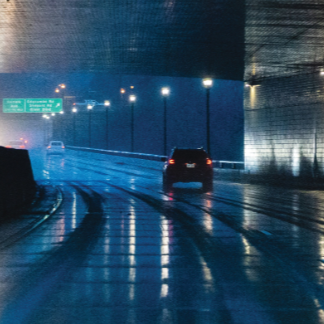 car driving through a road tunnel in the rain