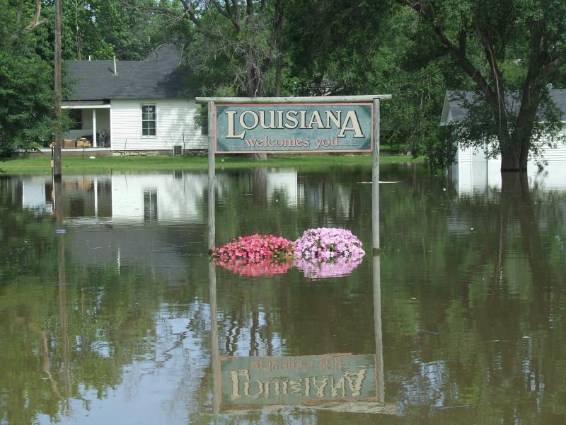 "Louisiana Welcomes You" sign nearly submerged in floodwater
