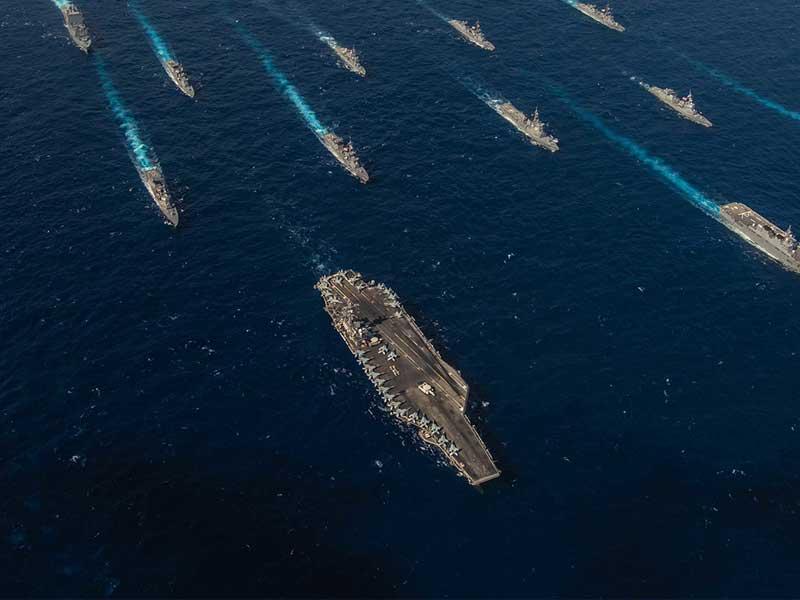 A picture of battleships at sea travelling in the same direction