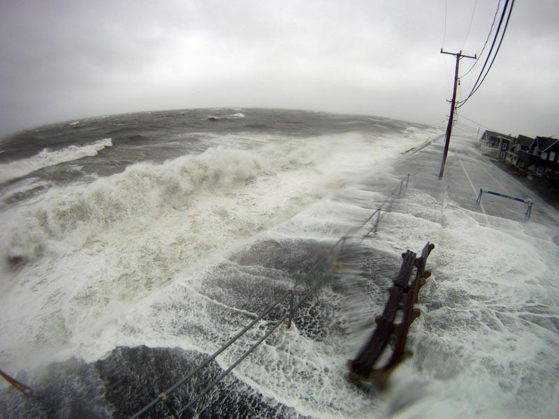 Photo of waves topping a coastal road 