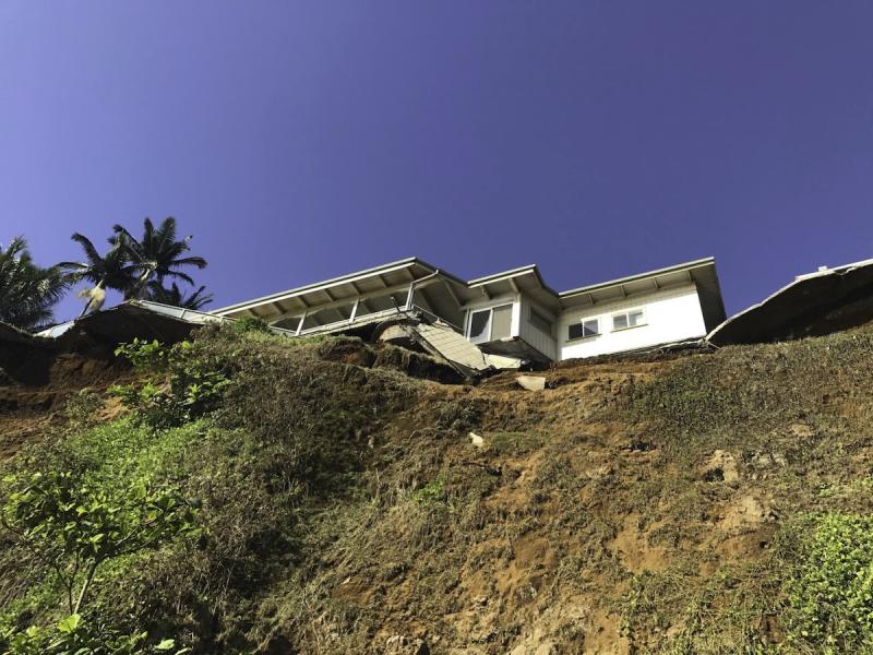 Beach-level view looking up at home with undercut cliff