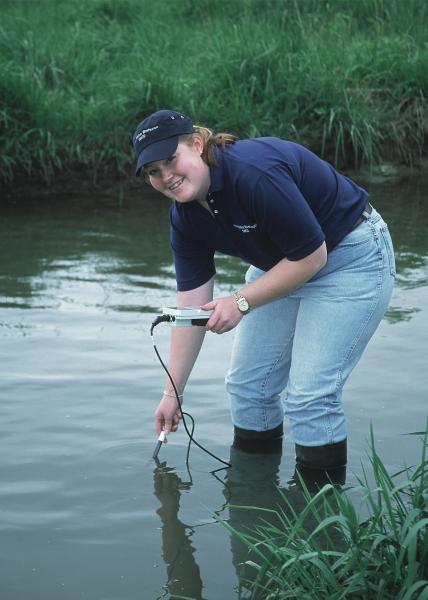 Photo of volunteer testing water quality.
