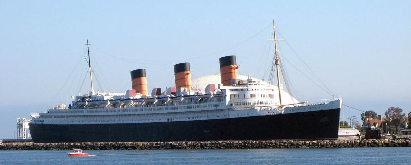 Docked ship with three smokestacks and dome in background