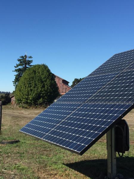 A solar panel near a barn
