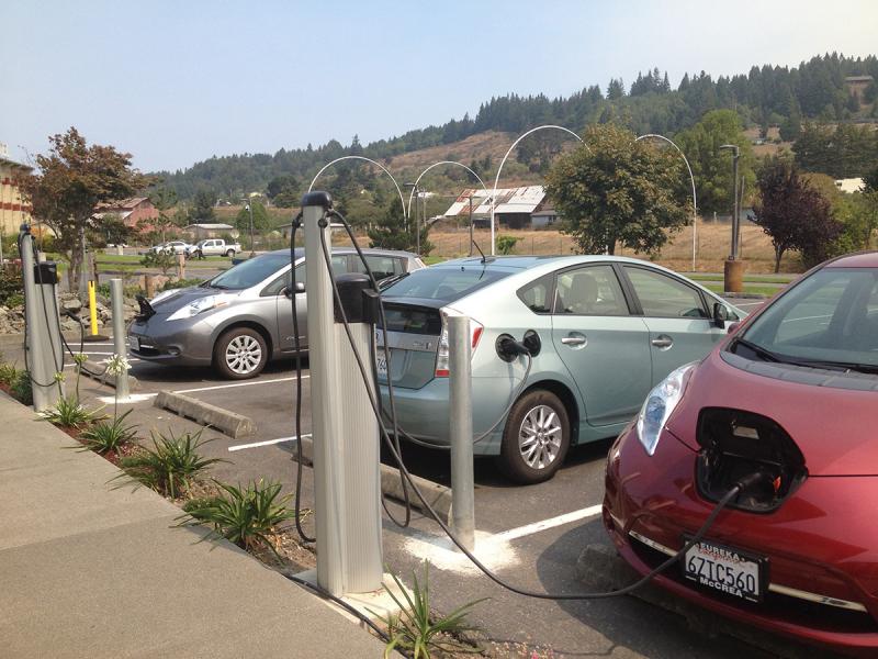 Two electric vehicles at charging stations