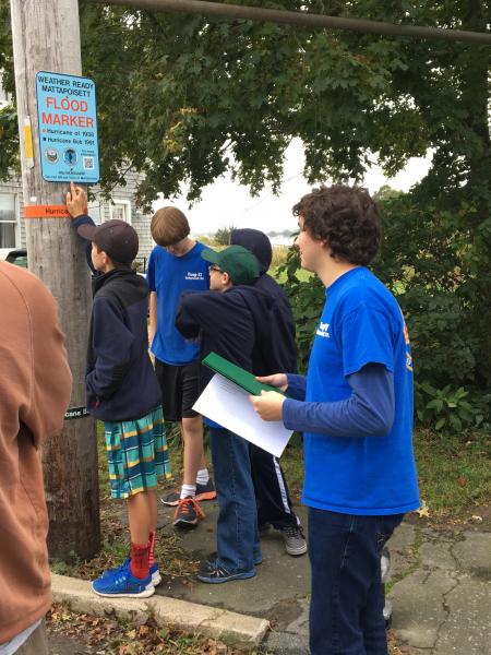 People looking at a flood marker sign