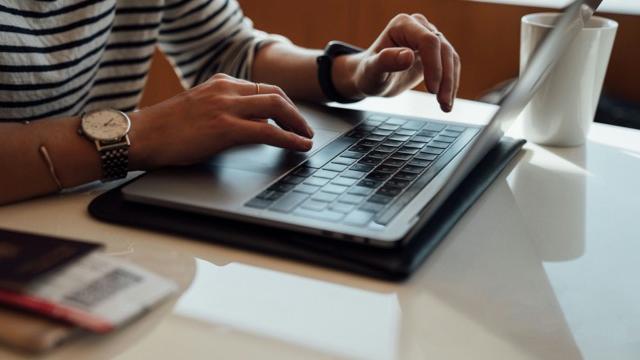 Close up of a woman's hands typing at a computer