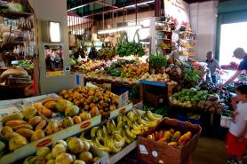 Indoor marketplace well stocked with local fresh fruits and vegetables.